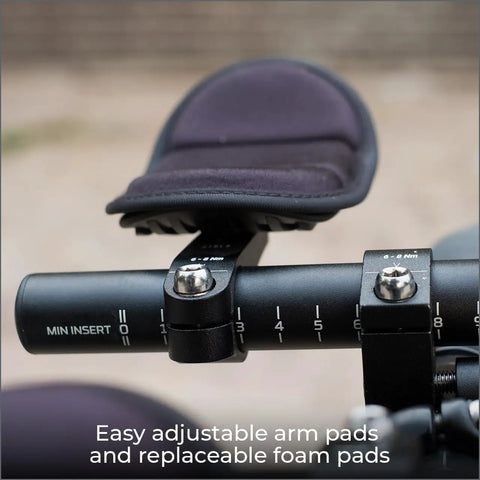 Close-up of aluminum two piece aero bars for road bikes with J bend design, showing adjustable arm pads and foam padding.
