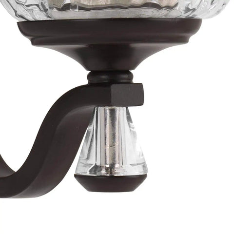 Close-up of Anjoux Collection 3-Light Clear Water Glass Luxe Bath Vanity Light fixture detail with bronze finish and glass accents.