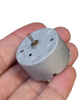 Tiny Powerhouse Mini DC Motor For DIY Projects 32mm Round Spindle With Carbon Brush in a hand close-up view