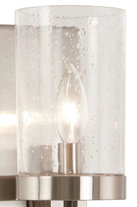 Close-up of Bridlewood Vanity Bath Light 1 Light Fixture Stone Grey with Brushed Nickel finish, clear seeded glass, lit bulb