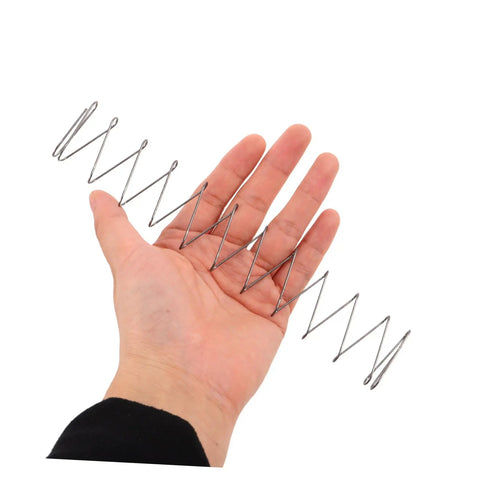 Hand holding Two Pack Industrial Trapezoidal Flat Compression Springs 1x9.5x35x160mm for heavy-duty machinery