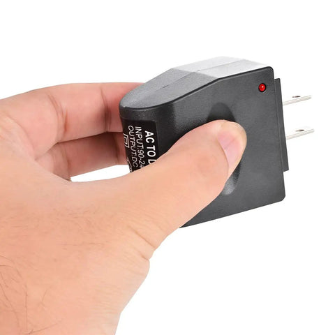 Plug And Go AC To DC Conversion Wall Outlet Adapter held in hand, compact design for 12 Volt 500 Milliamp charging.