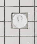 Rubber Bath Tub Drain Stoppers 4pcs with Pull Ring for Basins, white rubber plug installed in a shower drain.