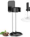 Electric Handheld Milk Frother With Stand For Coffee At Home, Milk Foamer And Mini Mixer For Frappe, Latte, Cappuccino And Matcha, Battery Operated Blender Frother That Keeps Counters Clean And Fresh shown with black wall-mounted stand and coffee beans.