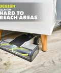 Heavy Hitting Cordless Stick Vacuum Cleaner With 18 Volt Battery And Quick Charger, cleaning under low furniture on hardwood floor.