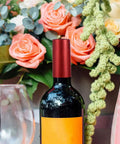 Premium Heat Shrink Wine Bottle Caps 100 Pack Flexible PVC Sealing Film on wine bottle with roses and greenery backdrop.