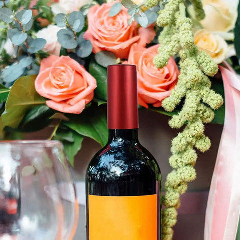 Premium Heat Shrink Wine Bottle Caps 100 Pack Flexible PVC Sealing Film on wine bottle with roses and greenery backdrop.