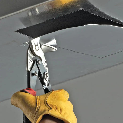 Left Cutting Aviation Snips With 90 Degree Forged Steel Jaws cutting overhead 24 gauge steel sheet, red non-slip grips visible