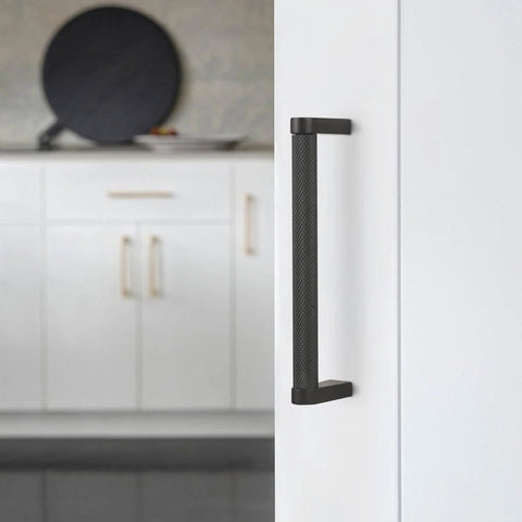 Close-up of 10 Pack 5 Inch Matte Black Knurled Cabinet Pulls for Cabinets and Drawers installed on a white kitchen cabinet door.