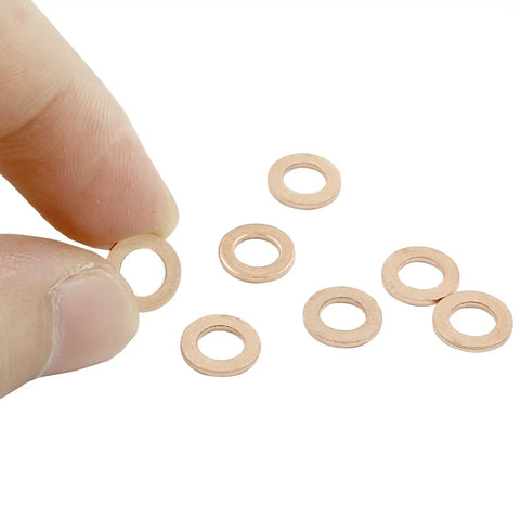 100 Pack M5 Copper Flat Washers 5X9X1mm held between fingers with others on a white background, rust proof hardware fasteners.