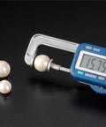 Jewelry-Making Digital Caliper measuring a pearl at 15.75mm with other pearls nearby, 25mm range, 0.01mm precision.