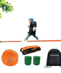 Child walking on 65ft Ninja Slackline Kit With Ratchet System And Tree Protectors, 500lb Capacity Backyard Set.