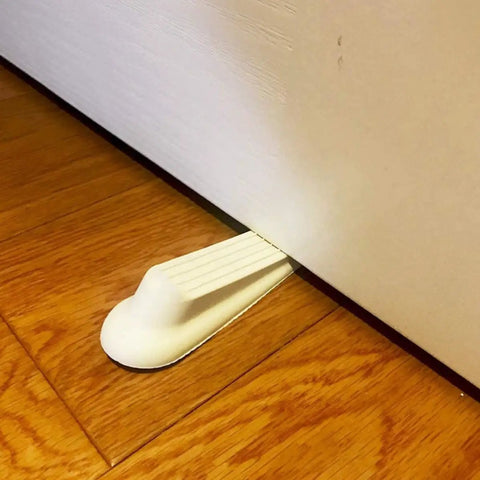 White Door Wedge Stopper Set 5 Pack Rubber Non Skid Wedge Shaped Door Stoppers holding a door open on wooden floor