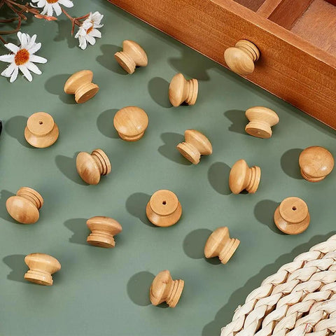 Pack Of Fifty Unfinished Wood Drawer Knobs In Classic Mushroom Shape One Inch Cabinet Handles arranged on a green surface.