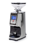 Rock Solid Hella Quiet Espresso Grinder Featuring Precision 65 Mm Flat Burrs And Compact Short Hopper Programmable Dosing Settings Deliver Wicked Shot Quality In Sleek Chrome Finish, side view with digital display.