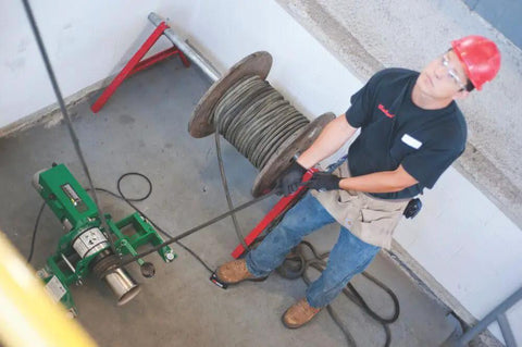 Electrician using Puller Assembly UT10 2S for durable cable pulling and conduit installations on job site.