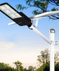 Beast Mode Bright 300W Solar Street Light With Remote Control installed outdoors on white pole, blue sky background.