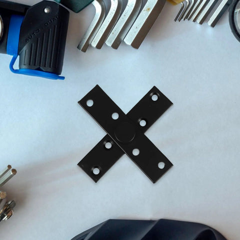 Close-up of Invisible 360 Degree Hidden Door Pivot Hinge for wooden doors and cabinets, black stainless steel, on table with tools.