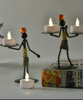 Two metallic figurines holding 100 Count Battery Powered LED Tea Lights Flameless Flickering Warm White Candles Long Lasting CR2032