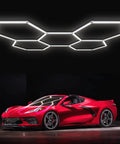 Hexagon Garage Lights 25 Pack LED Ceiling Fixtures 168W 21840 Lumens 6700K Daylight White For Car Detailing Shop Gym Workshop Basement Flicker Free Eye Friendly Mega Bright Crisp Daylight Coverage installed above a red sports car.