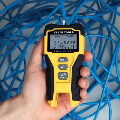 Person holding LAN Scout Jr 2 Ethernet Cable Tester For CAT5e CAT6 CAT6A RJ45 Cables With Backlit LCD wiremap display.