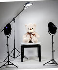 Stunning White Motorized Rotating Display Stand With Mirror Finish Turntable For Jewelry Watches Digital Gadgets And Collectibles 5Kg Capacity Smooth Spinning Showcase For Photography Retail Stores with light setup and teddy bear.