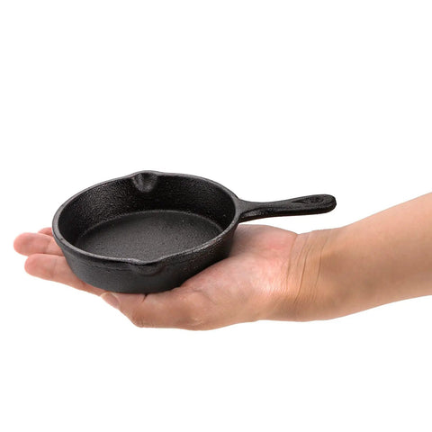 Person holding one of the Four Pack Mini Cast Iron Skillets 4 Inch With Double Drip Spouts, Stove Oven Grill Safe, Indoor Outdoor Use, Nonstick Finish