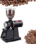 Portable Stainless Steel Electric Conical Burr Coffee Grinder With Eight Gear Precise Settings For Espresso Drip French Press Spice Nut And Grain Grinding Badass Build No Sweat Grind Setup next to coffee beans.