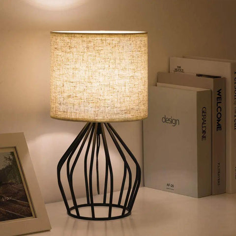 Black Modern Table Lamp With Linen Fabric Shade And Hollowed Base, Compact Bedside Light for Bedroom or Living Room on desk.