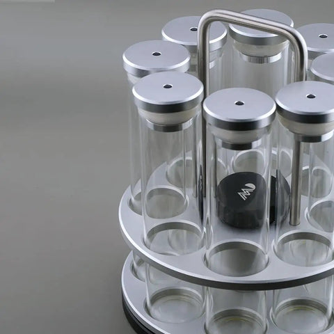 Eight Single Dose Espresso Bean Storage Tubes With Rotating Display Rack And Precision Funnel Set, clear tubes with silver lids.