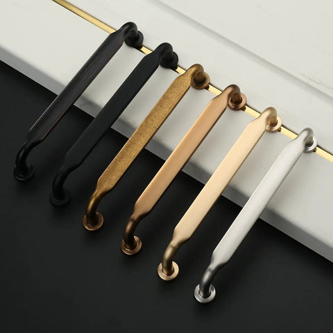 10 Pack 5 Inch Champagne Bronze Cabinet Handles with various finishes displayed on countertop, designed for kitchen and drawer use.