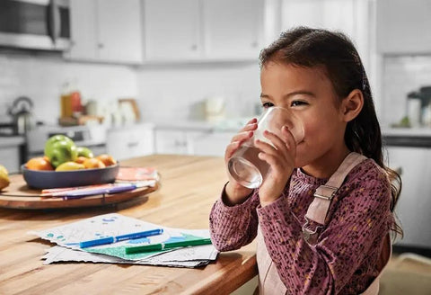 Child happily drinking fresh water in kitchen using PureSource WFCB Refrigerator Water Filter Replacement For Crisp H2O