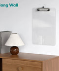 Clear Plastic Clipboard 2 Pack For 8.5 By 11 Papers, Letter Size hangs on wall above a wooden desk with a lamp and books.