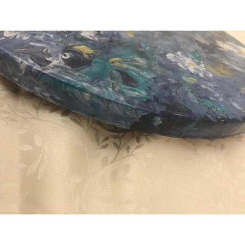 Side view of 16 Inch Floral Resin Lazy Susan on Wood Serving Tray Base, showcasing blue, gold, and white floral patterns on resin surface.