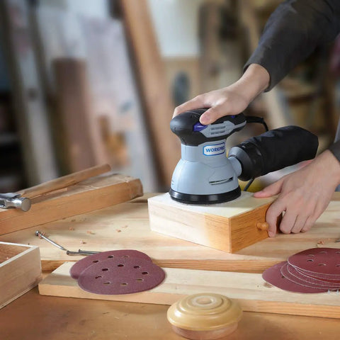 Person using random orbital sander with 5 Inch 8-Hole Sanding Disc Set With Hook And Loop Includes Grits 60 80 100 120 180 240 320 400