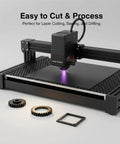 Front view of a laser engraver cutting a black acrylic sheet on its bed.