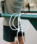 6mm PVC Jump Rope Adjustable All White Fitness Skipping Rope With Unbreakable Handles And Non Kinking Cord Built To Last Cardio Favorite For Indoor And Outdoor Workouts For Men And Women hanging on a bar outdoors