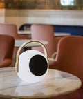 Eye Color Changing LED Lantern With 10W Bluetooth Speaker on round marble table in lounge setting