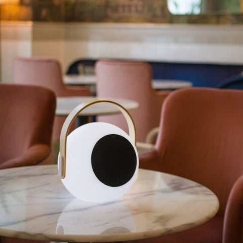 Eye Color Changing LED Lantern With 10W Bluetooth Speaker on round marble table in lounge setting