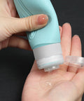 Close-up of a hand using On The Go Travel Bottles For Toiletries Set 5 Pack TSA Approved 3oz Leak Proof Refillable Containers.