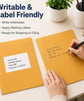 Person writing on 10x13 Inch Kraft Mailing Envelopes With Gummed Seal Closure 28lb Heavyweight Manila Catalog Envelopes for office use
