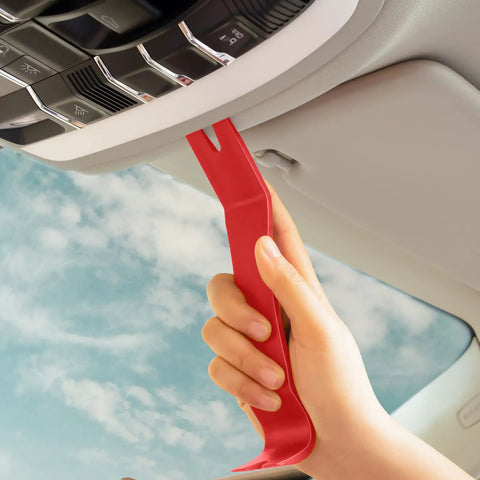 Hand using a red nylon tool from Snag These Dope 5 Piece Nylon Auto Trim Removal Tools For Your Ride for car dashboard repairs.