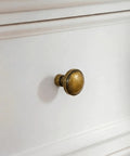 Vintage Antique Brass Cabinet Knobs And Drawer Handles 1 1/4 Inch on a white dresser, showcasing solid zinc alloy construction.