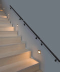 Rock Solid Heavy Duty Wall Mounted Stair Handrail Featuring Matte Black Stainless Steel Cylinder Rods For Killer Grip And Effortless Home Installation Projects on wooden stairs with lights.