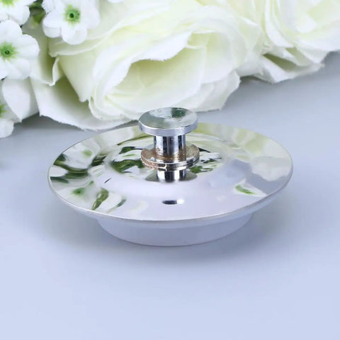 Bathtub Stopper for 40-45mm Holes Flat Cover Stainless Steel on a surface, showing its shiny flat design and drain fitting.