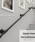 Black Wrought Iron Stair Handrail Wall Mounted Indoor Outdoor Support Bar With Kickass Ergonomic Grip Built Tough For Daily Use Senior Safety Adjustable Length Weather Resistant on gray wall with framed art.