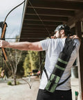 Archer using Lightweight Back Arrow Quiver With MOLLE System in army green, adjustable holder, bow hunting outdoors.