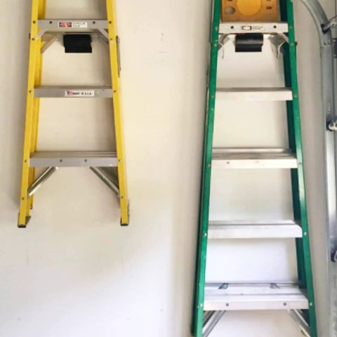 Garage Wall Ladder Hooks 2 Pack, Heavy Duty Wall Mount Hanger For Ladders And Tools, Wheelbarrows, Patio Furniture And More installed holding ladders.