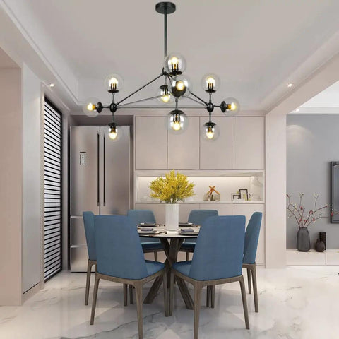 10 Light Modern Black Sputnik Chandelier With Clear Globe Shades in dining room with blue chairs and white decor.
