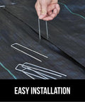 Beefy 6 Inch Landscape Staples 50 Pack 11 Gauge Galvanized Steel Stakes With Ultra Sharp Tip being installed in weed barrier fabric.